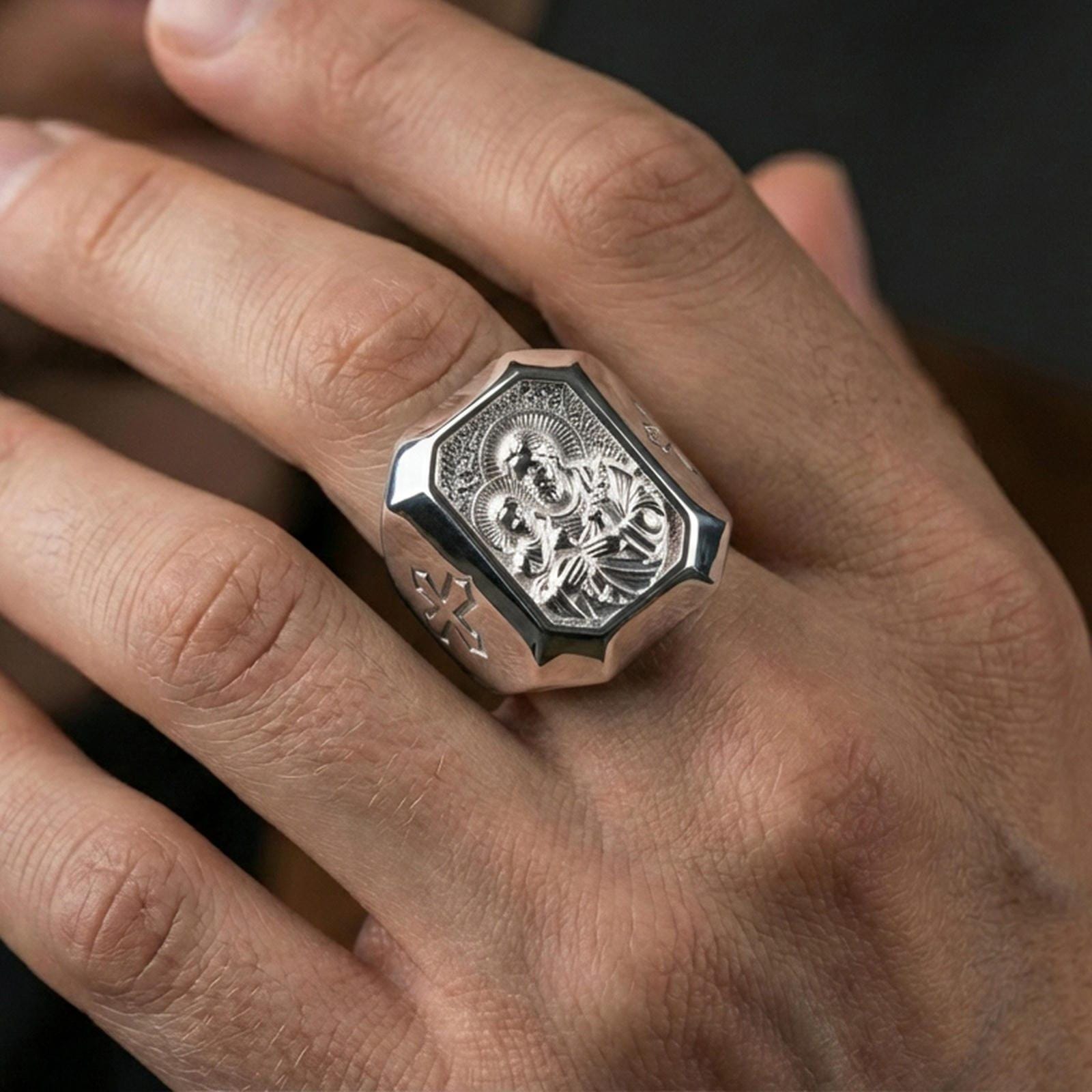 Polished silver St Joseph signet ring worn on finger, detailed holy father medal, Christian signet ring lifestyle shot