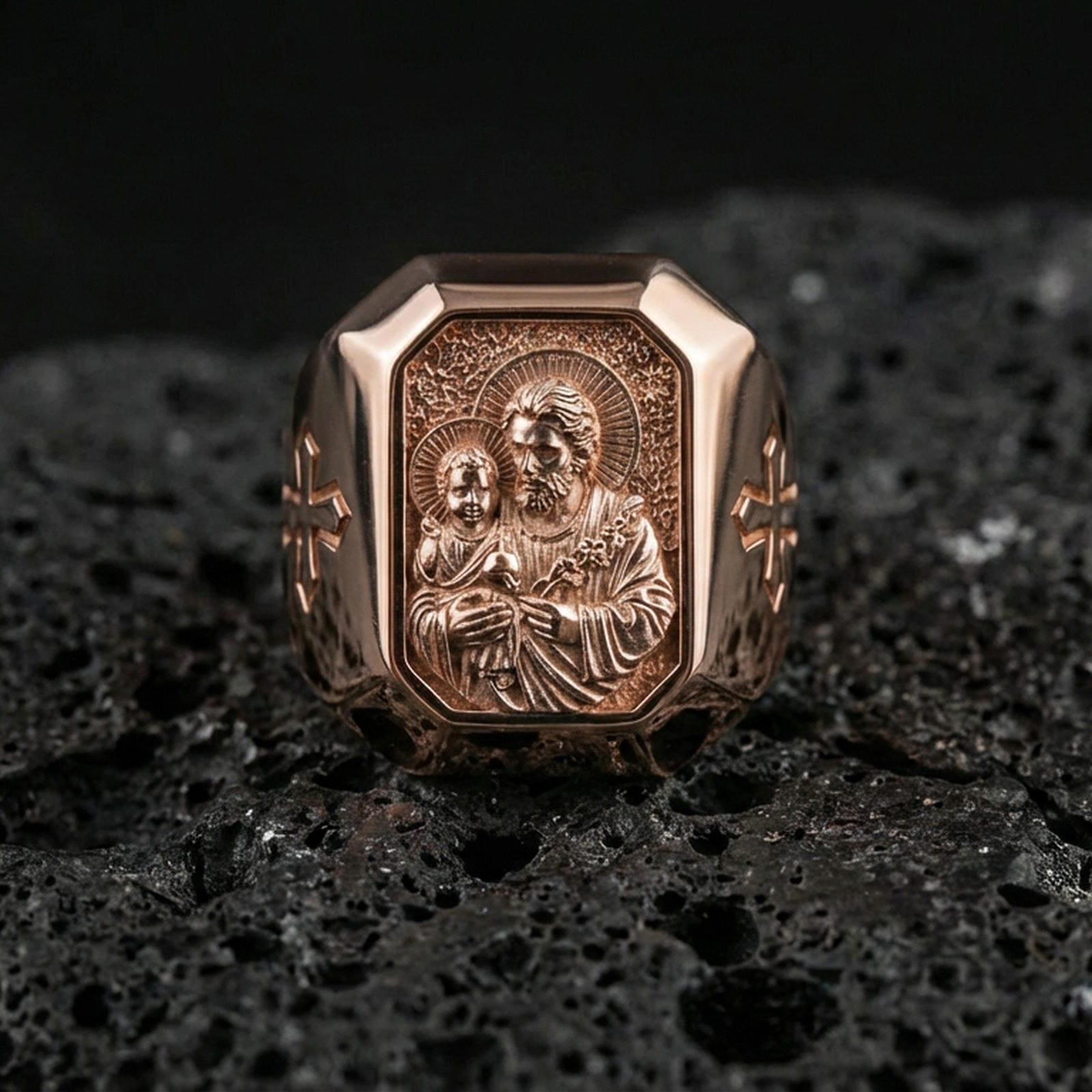 Rose gold plated St Joseph signet ring on volcanic stone, octagon saint medal face, Christian signet ring macro photo