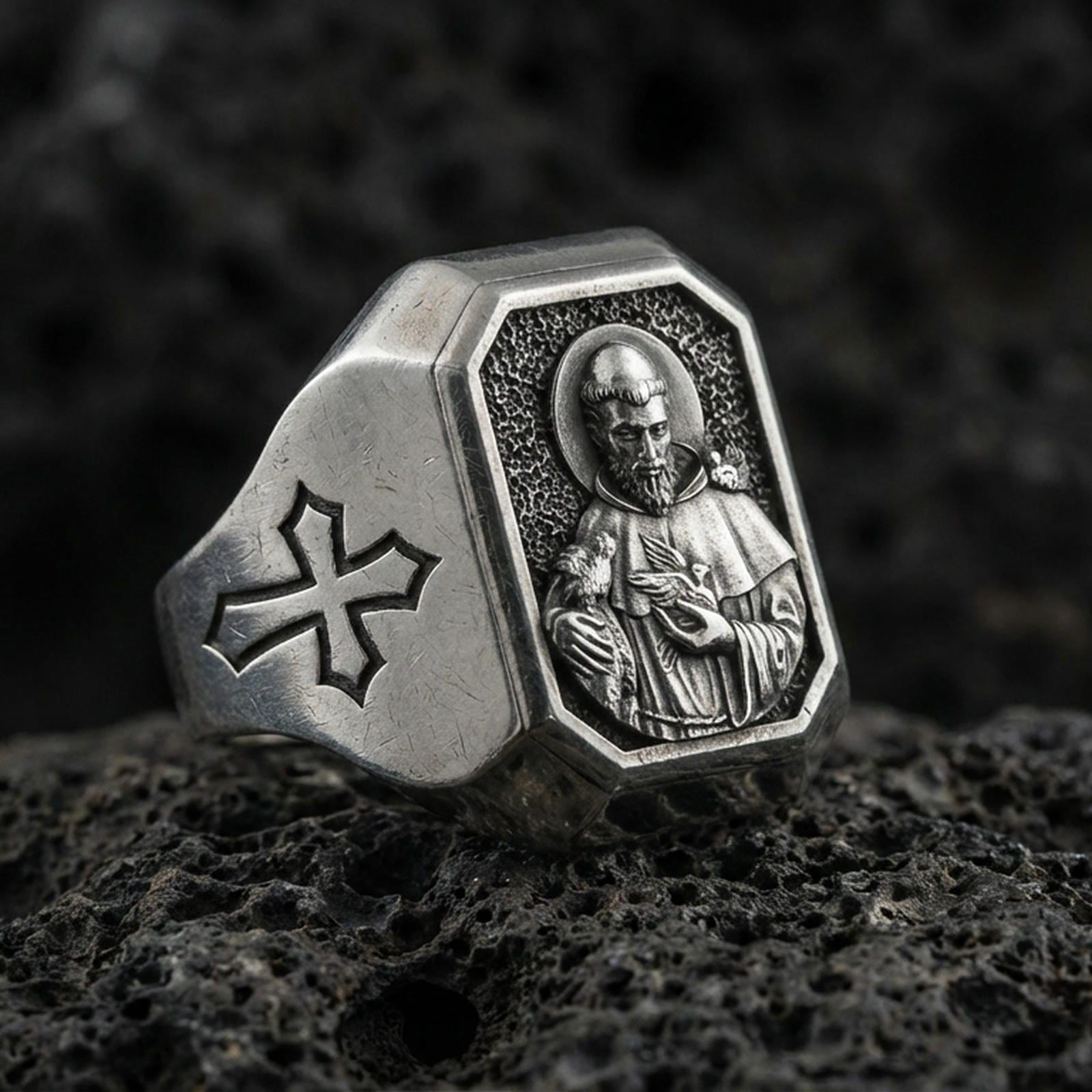 Oxidized sterling silver St Francis signet ring on volcanic rock, saint relief portrait, cross side engraving