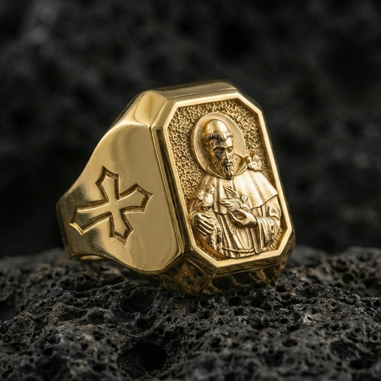 Gold plated St Francis signet ring on dark volcanic rock, saint portrait relief, cross side detail