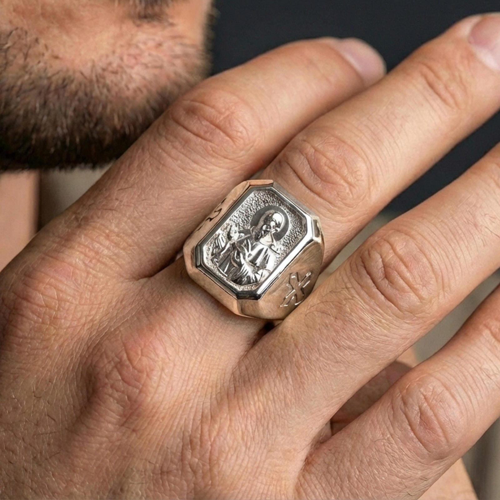 Polished silver St Francis signet ring worn on finger, detailed halo portrait, Christian devotion jewelry