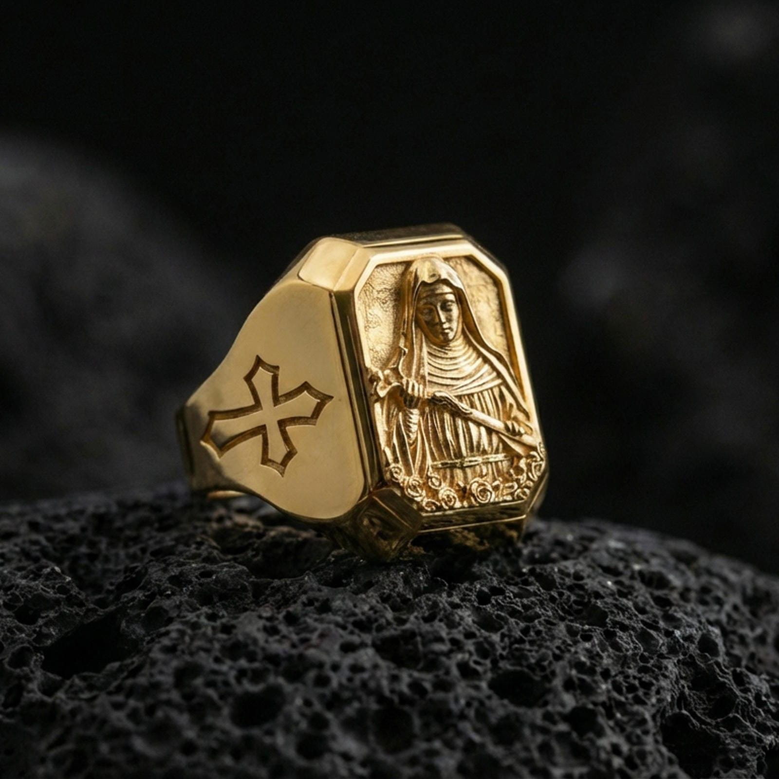 Gold plated St Rita of Cascia signet ring on dark volcanic rock, saint relief carving, cross side detail