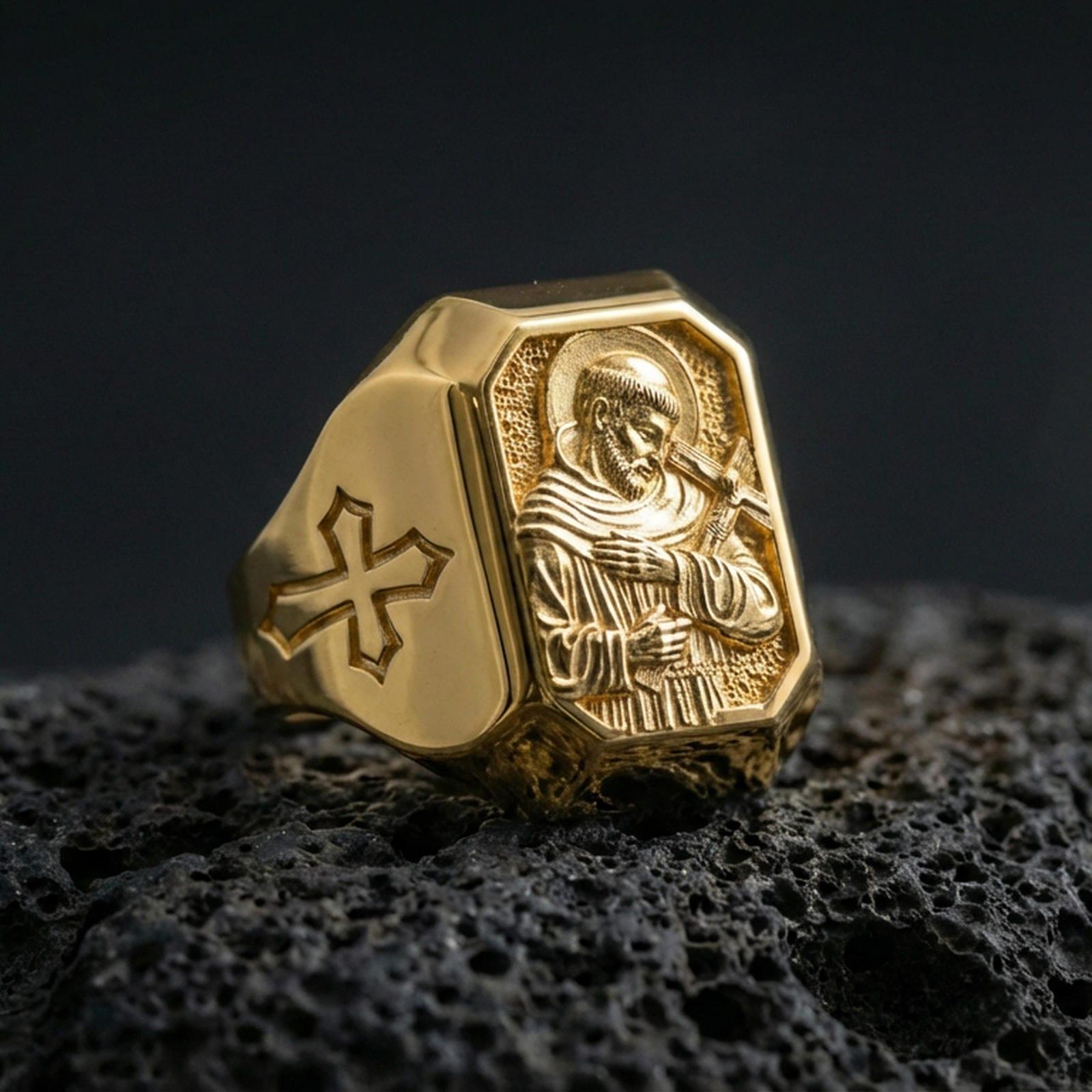 Gold plated Saint Francis signet ring on dark volcanic rock, detailed saint relief, cross side accent