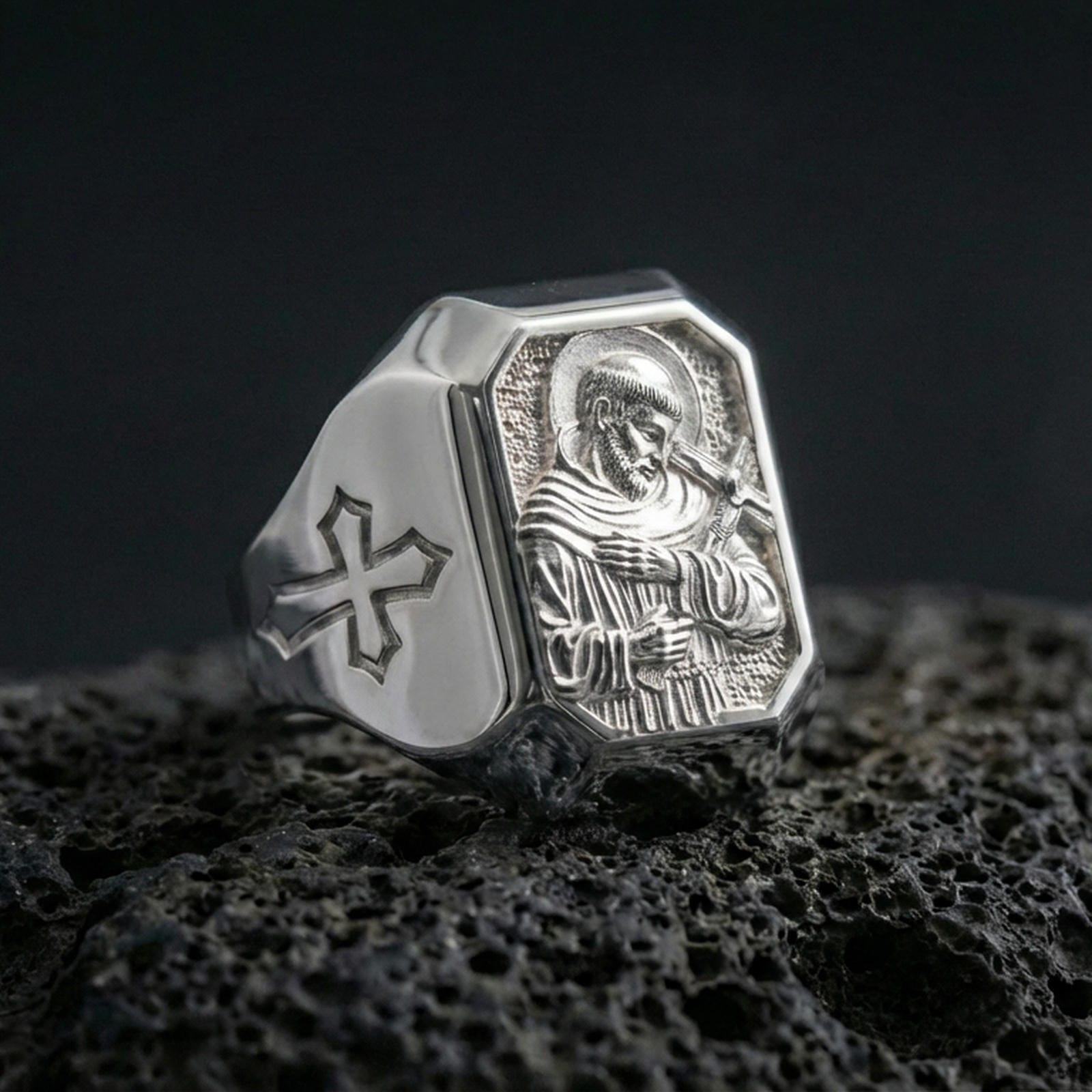 Polished silver Saint Francis ring on porous volcanic stone, halo relief engraving, Christian signet jewelry
