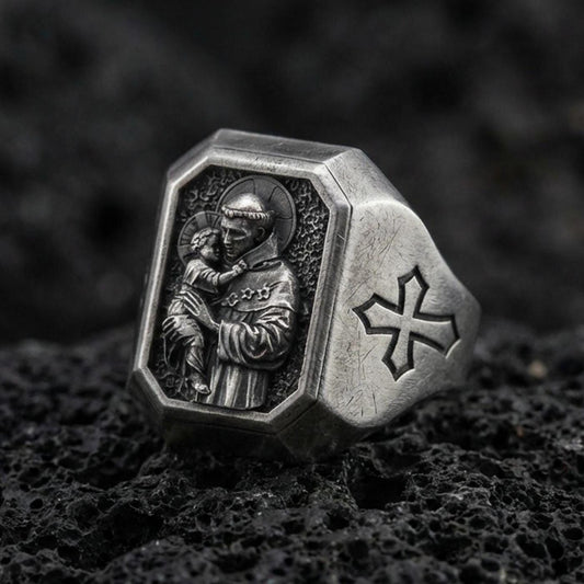 Oxidized sterling silver St Anthony signet ring on volcanic rock, saint holding child relief, cross shoulder engraving