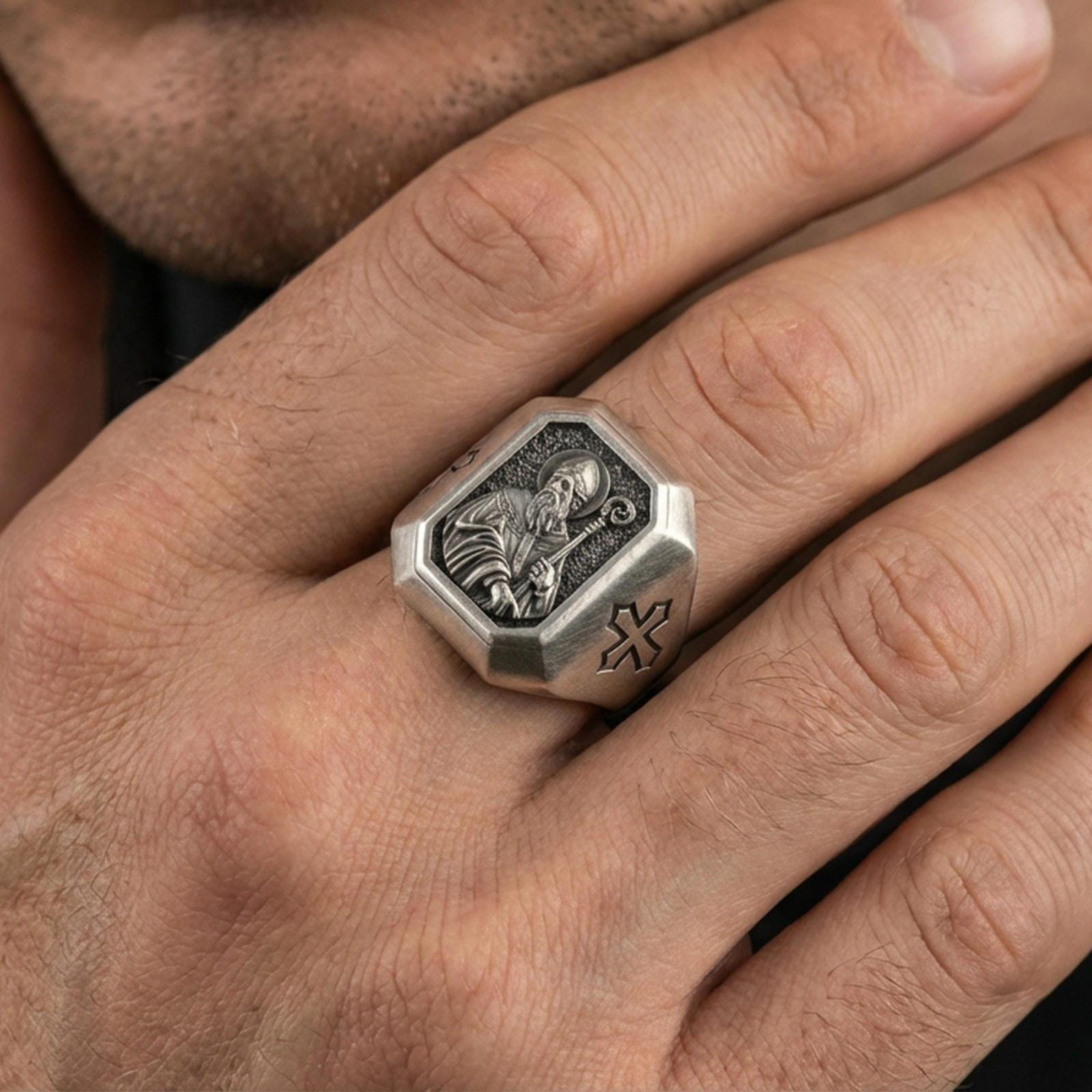 Oxidized sterling silver St Patrick ring worn on finger, bishop portrait relief with crozier, cross shoulder engraving