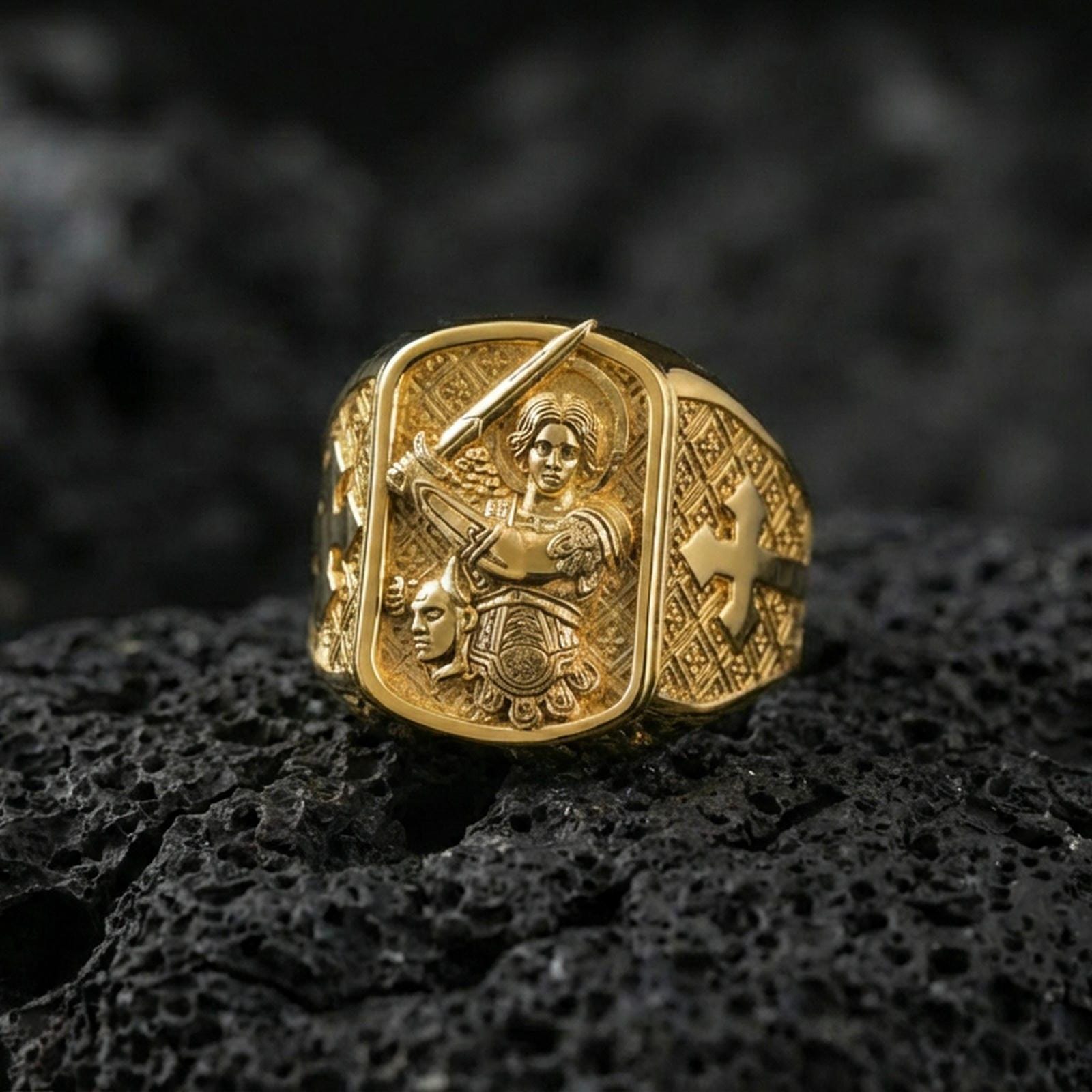 Gold plated Saint Michael archangel ring on dark volcanic rock, defeating devil relief, protective Christian jewelry gift