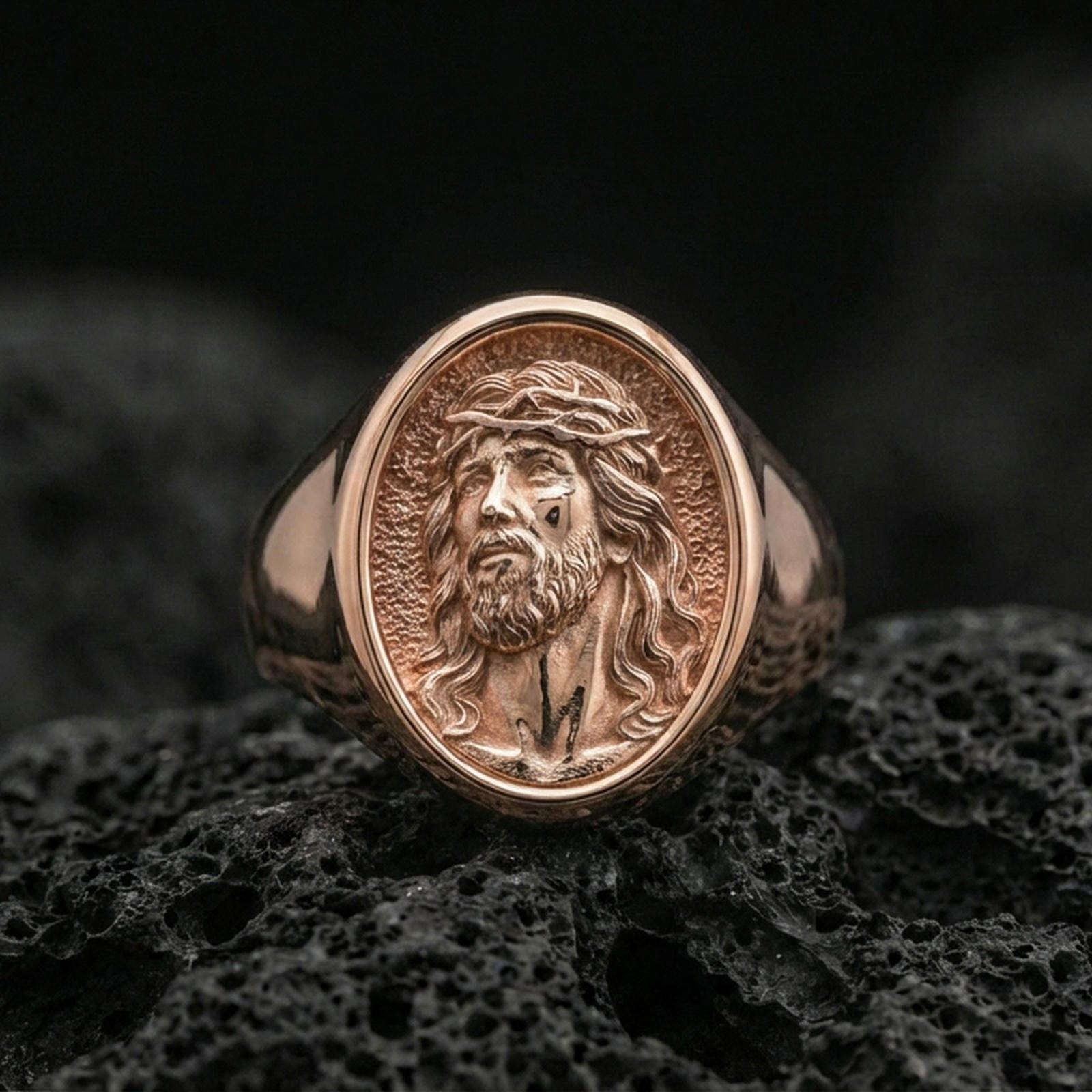 Rose gold plated Jesus portrait ring on volcanic stone, Christian faith signet ring macro detail