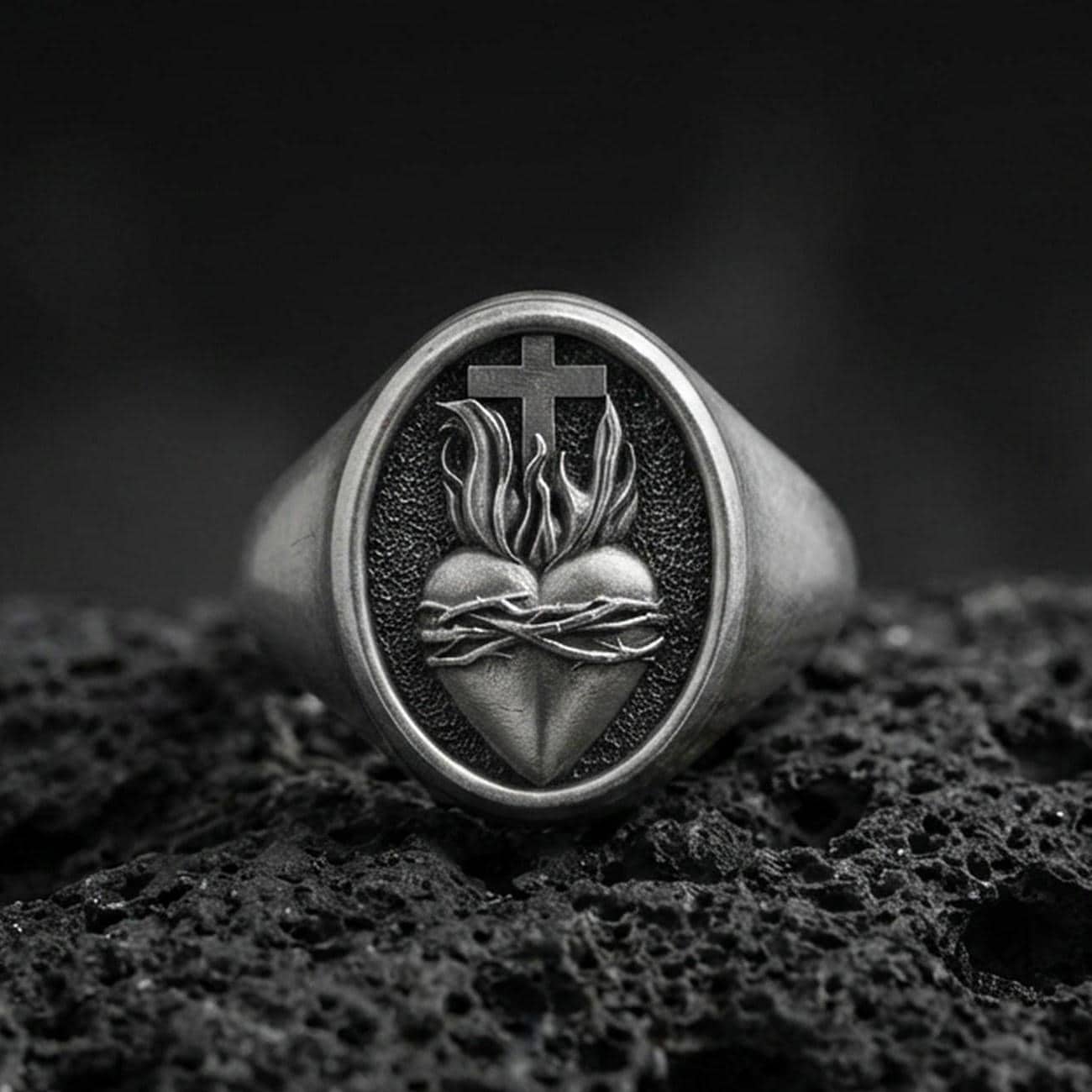 Oxidized sterling silver Sacred Heart signet ring on volcanic rock, thorned heart and cross relief, Catholic jewelry