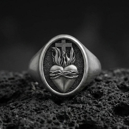 Oxidized sterling silver Sacred Heart signet ring on volcanic rock, thorned heart and cross relief, Catholic jewelry