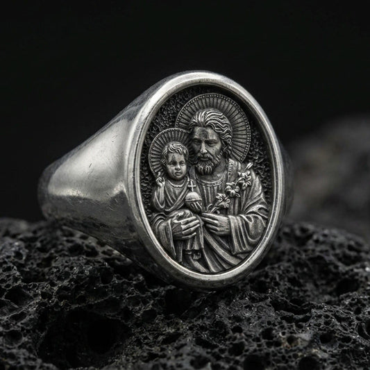 Oxidized 925 sterling silver St Joseph signet ring on volcanic rock, Holy Family relief closeup