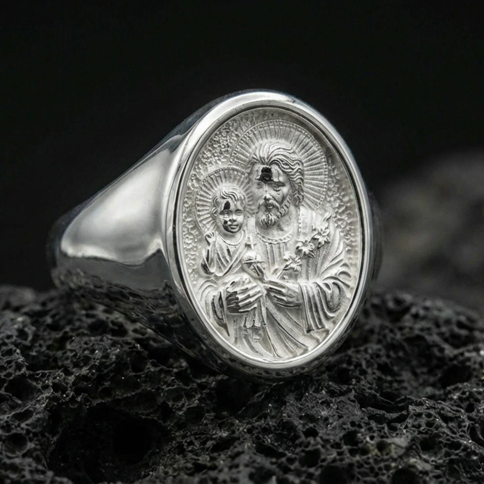 Polished silver Saint Joseph ring on volcanic stone, Catholic signet ring detailed macro