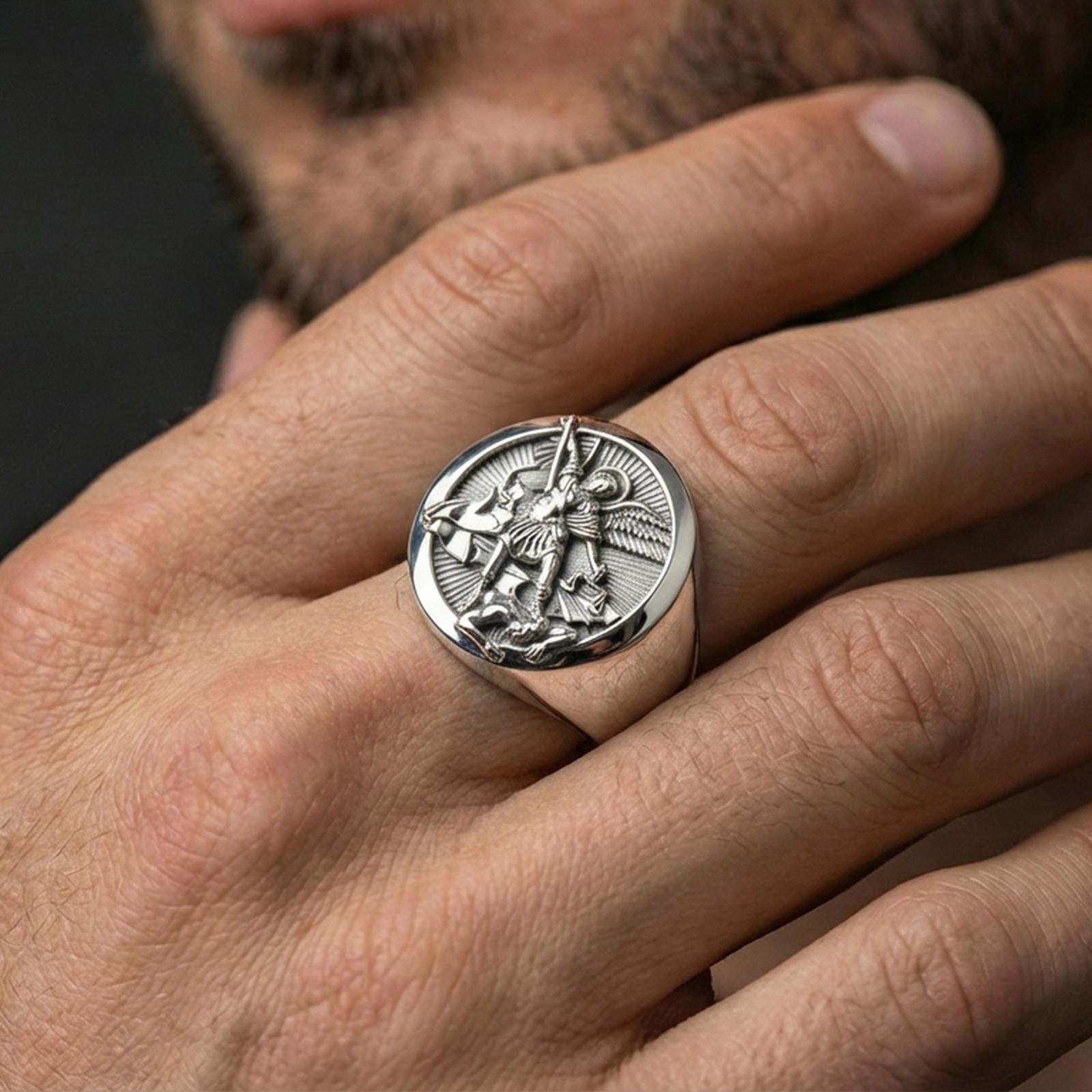 Polished silver St. Michael signet ring worn on finger, archangel warrior relief, meaningful religious accessory
