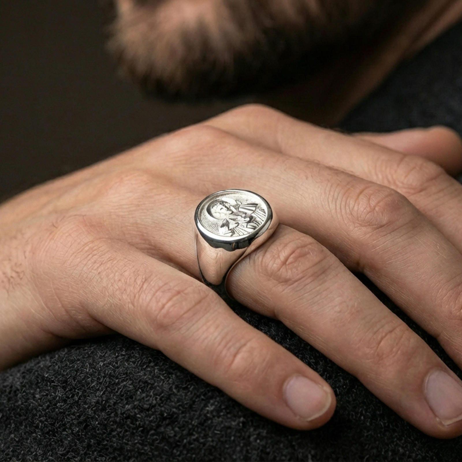 Polished silver St Francis signet ring on hand, Catholic mens ring lifestyle close view