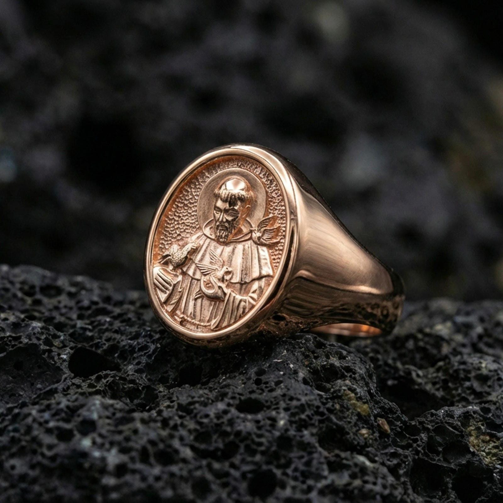 Rose gold plated St Francis signet ring on volcanic rock, religious jewelry gift for him