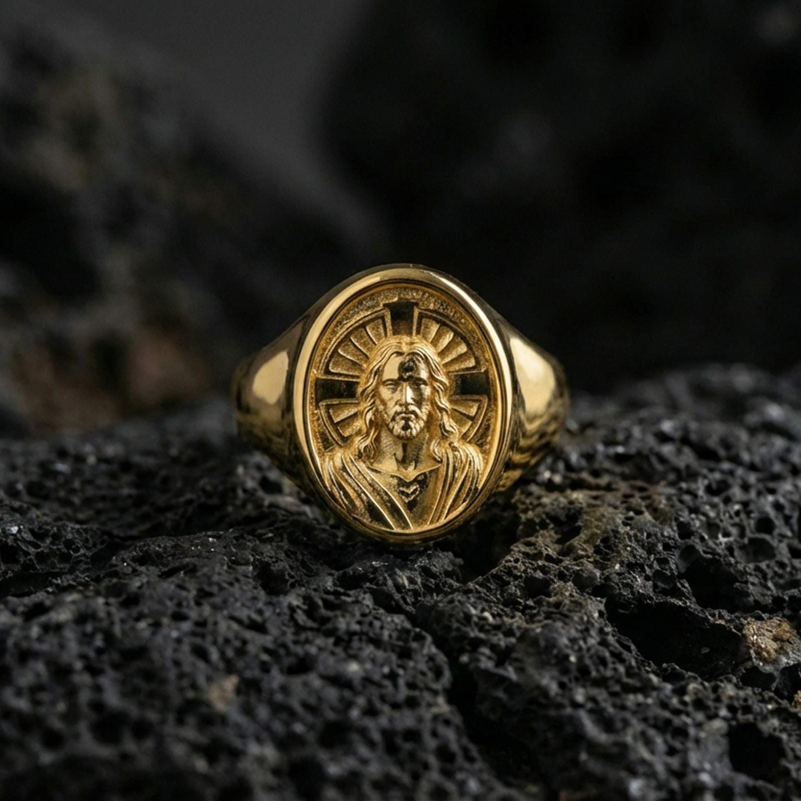 Gold plated Jesus Christ signet ring on dark volcanic rock, icon-style Christ portrait, religious accessory