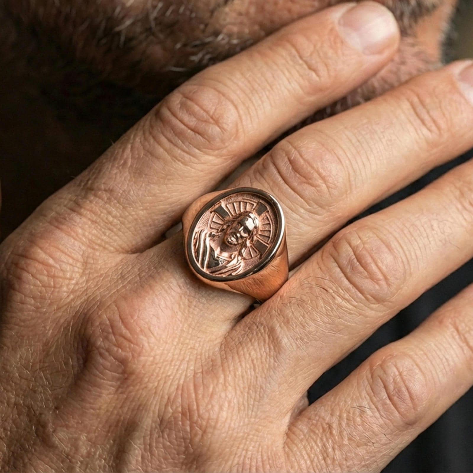 Rose gold plated Jesus Christ signet ring worn on finger, halo cross motif, meaningful Christian accessory