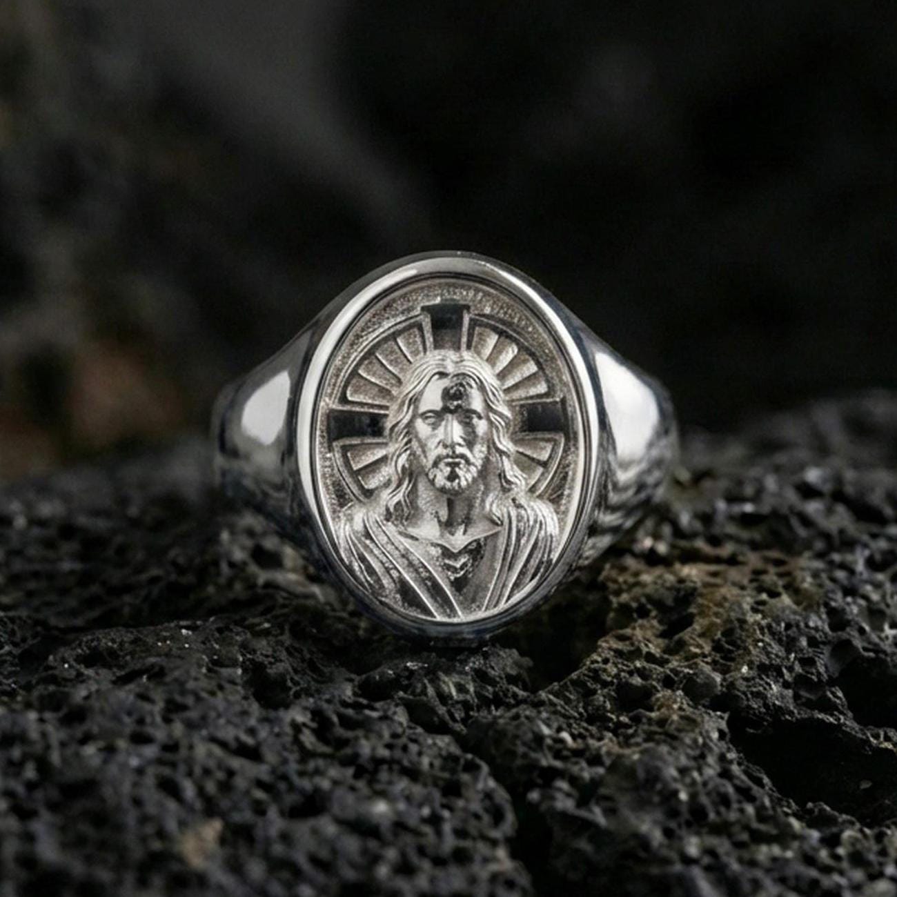Polished silver Jesus Christ signet ring on porous volcanic stone, radiant cross halo design, Christian jewelry