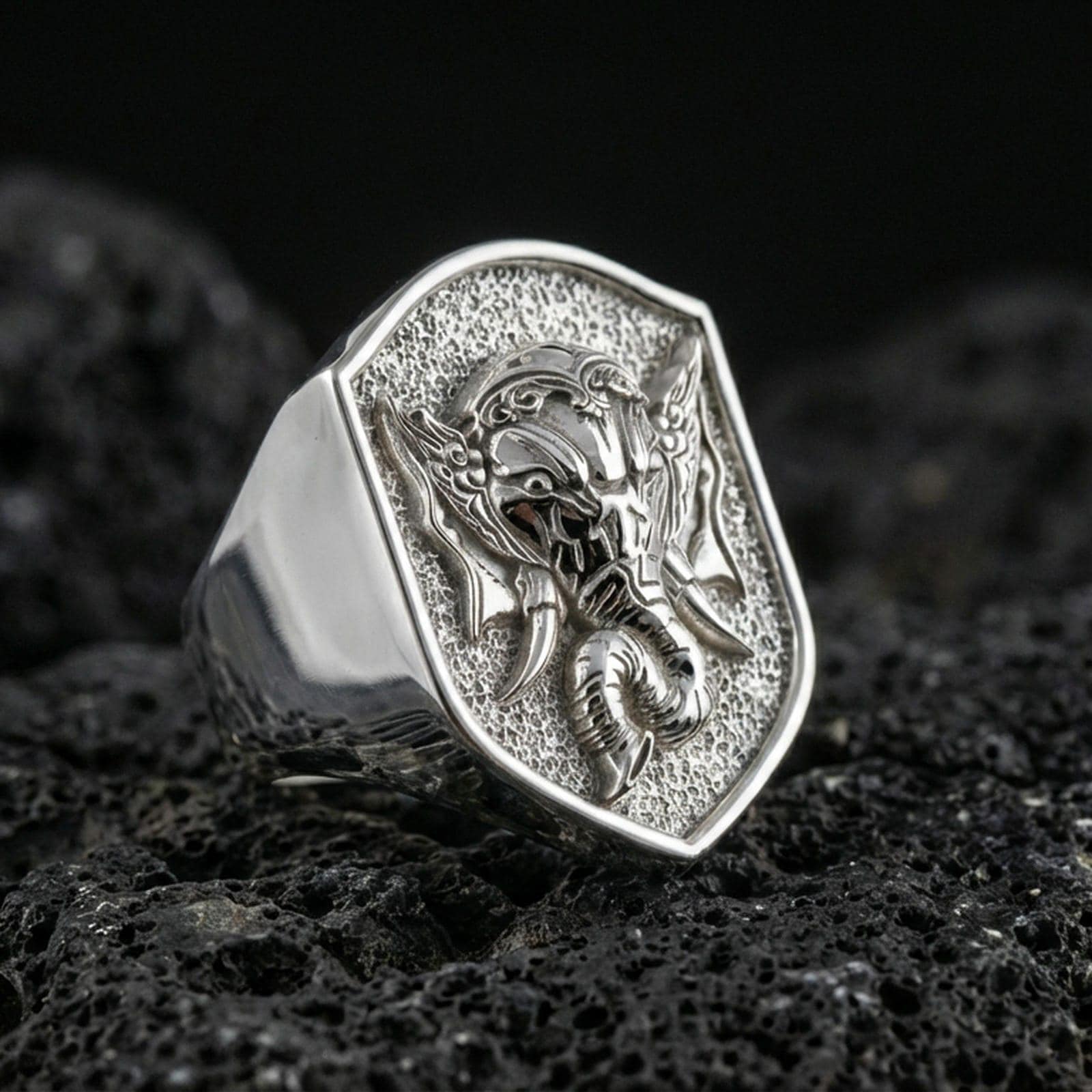Polished silver Lord Ganesha signet ring on porous volcanic stone, detailed Ganesh engraving, spiritual statement ring
