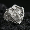 Load image into Gallery viewer, Polished silver Saint George and dragon shield ring on porous volcanic stone, detailed relief carving, statement signet style
