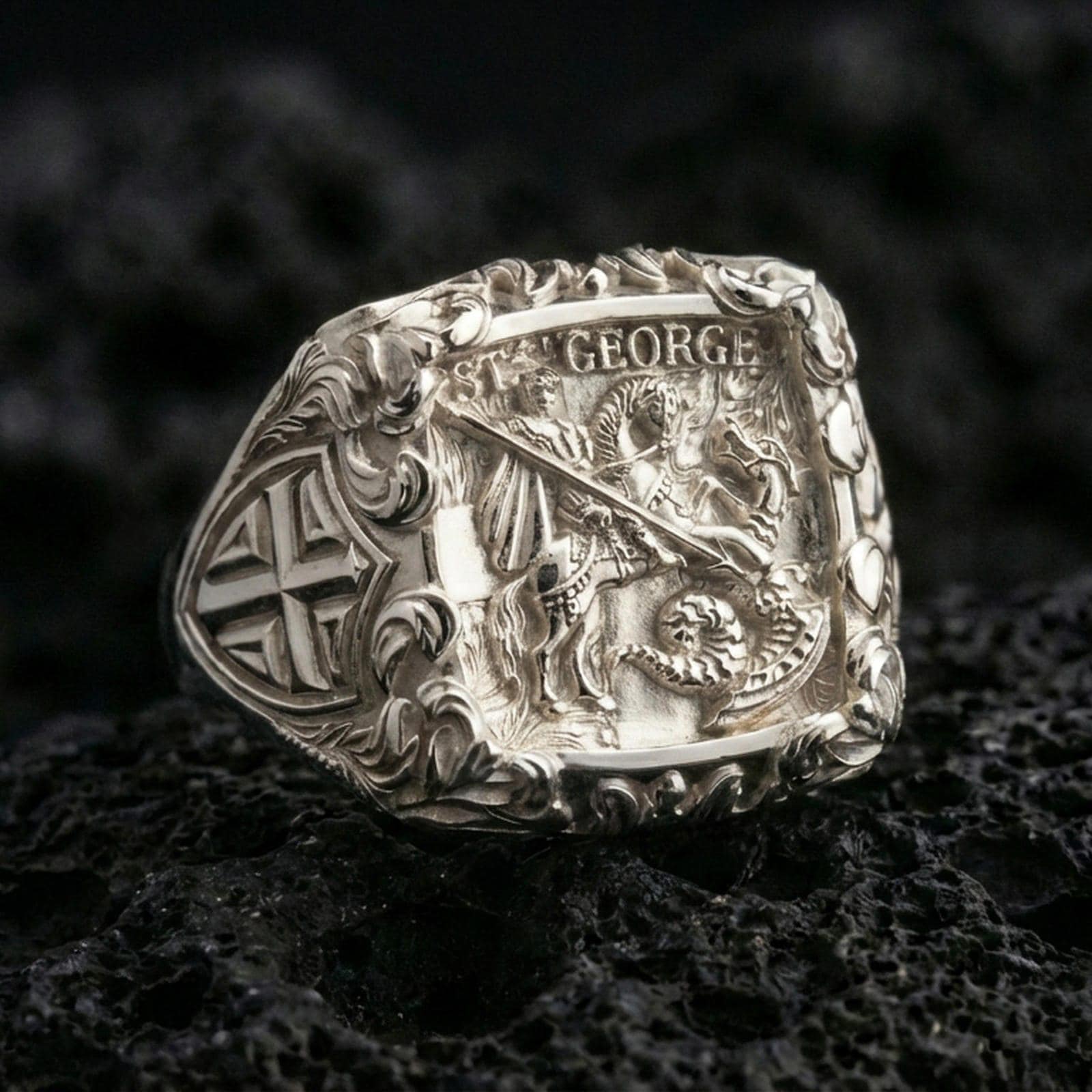 Polished silver St George shield ring on porous volcanic stone, detailed cavalry relief with “ST. GEORGE” banner