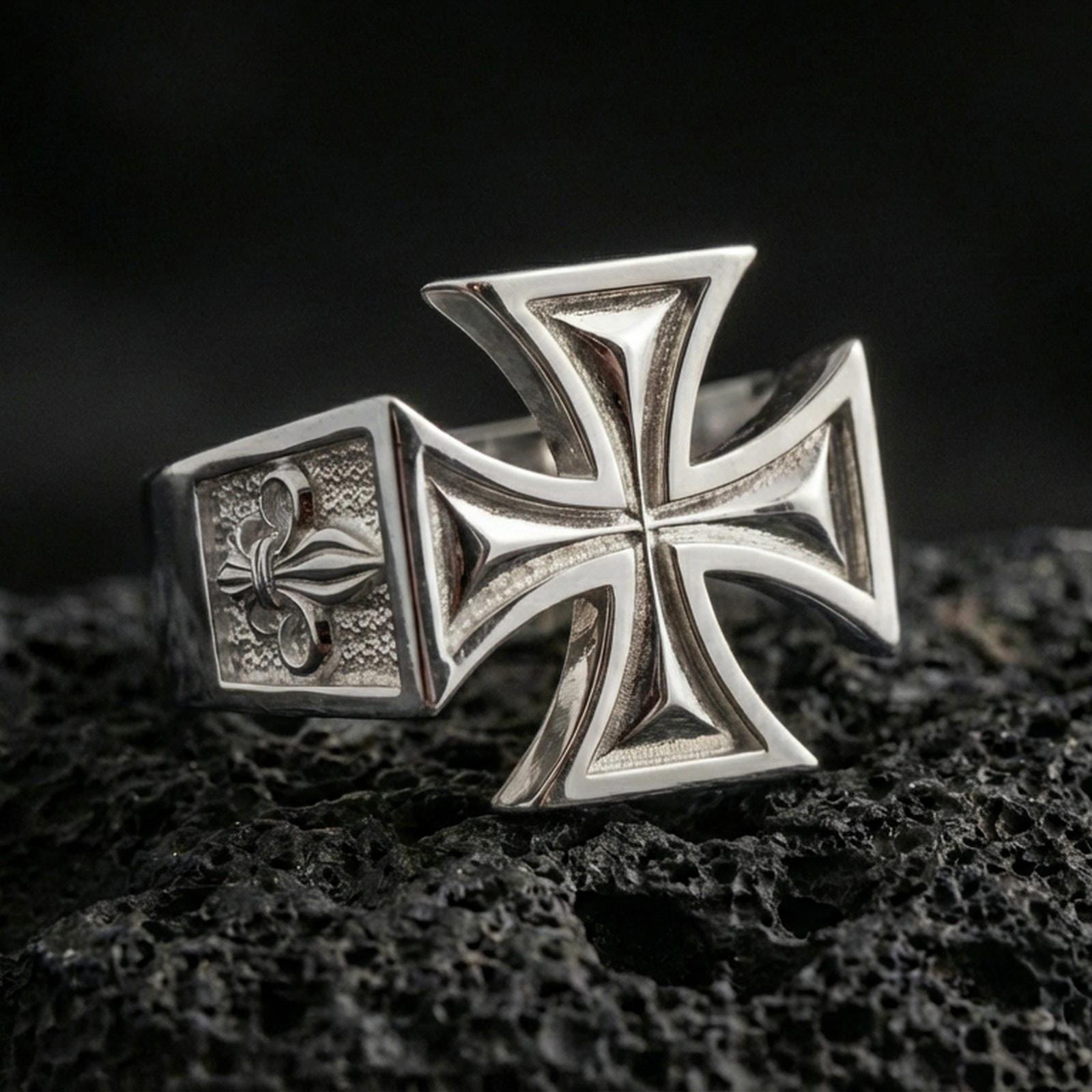 Polished silver iron cross ring on porous volcanic stone, sharp geometric cross design, heavy signet profile