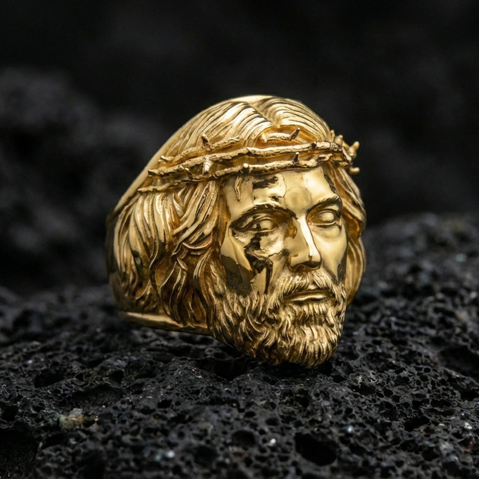 Gold plated sterling silver Jesus head ring on dark volcanic rock, crown of thorns portrait, religious statement jewelry