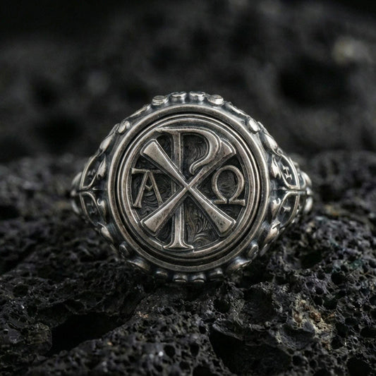 Oxidized 925 sterling silver Chi Rho ring on volcanic rock, Alpha Omega Christian symbol, detailed round signet
