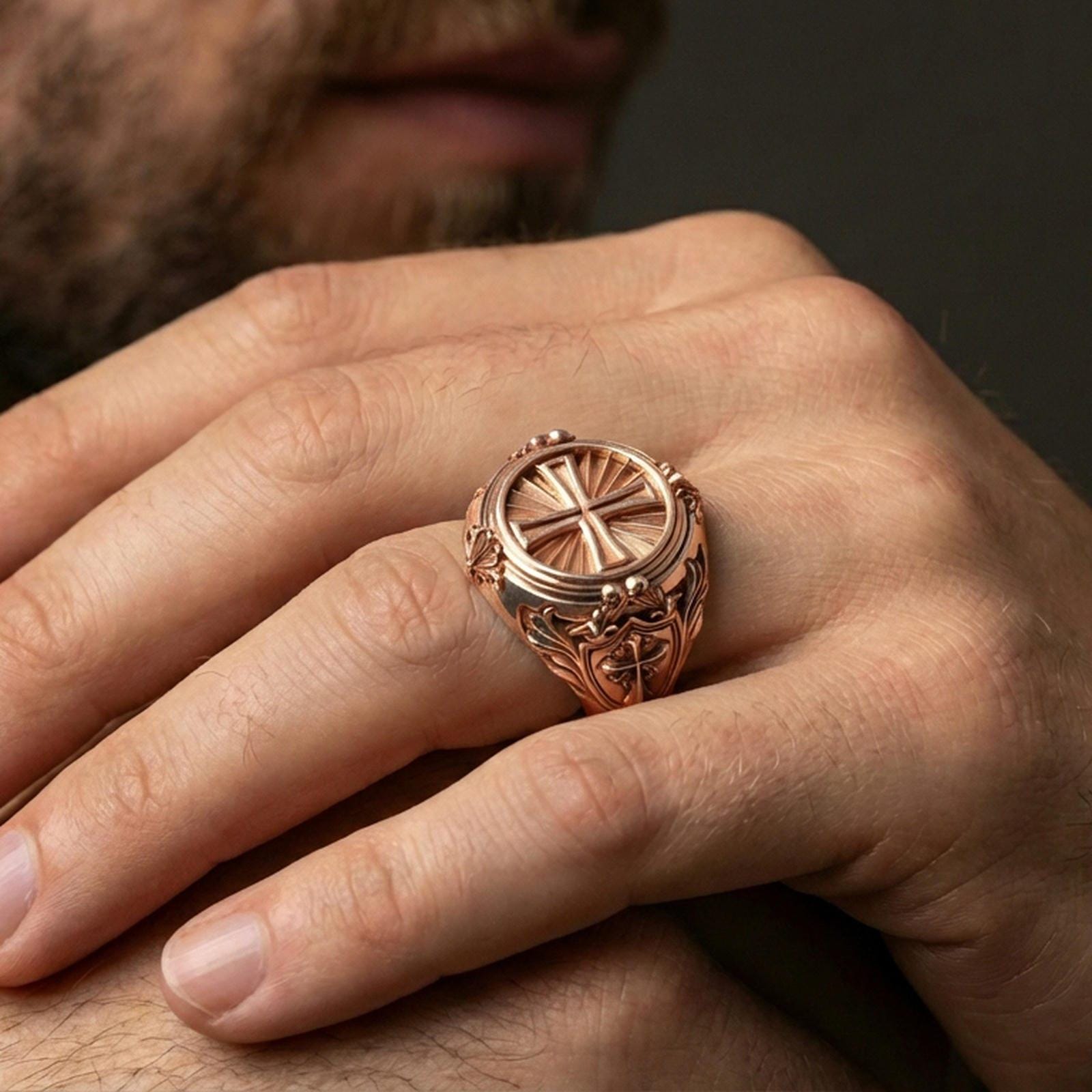 Rose gold plated cross signet ring worn on finger, round sunburst face, ornamental faith statement ring