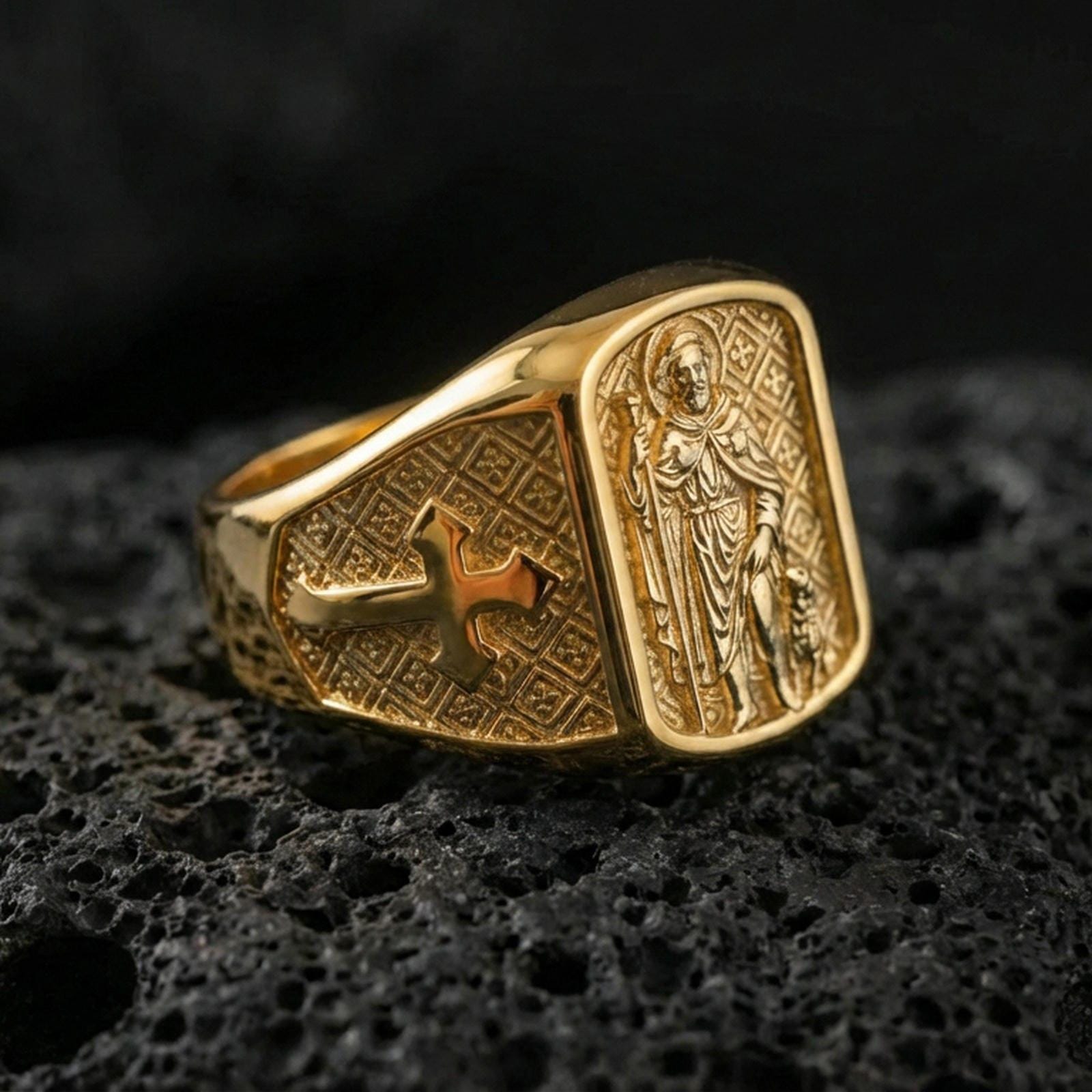 Gold plated Saint Roch signet ring on dark volcanic rock, patron saint of protection relief, engraved cross shoulders and vintage texture