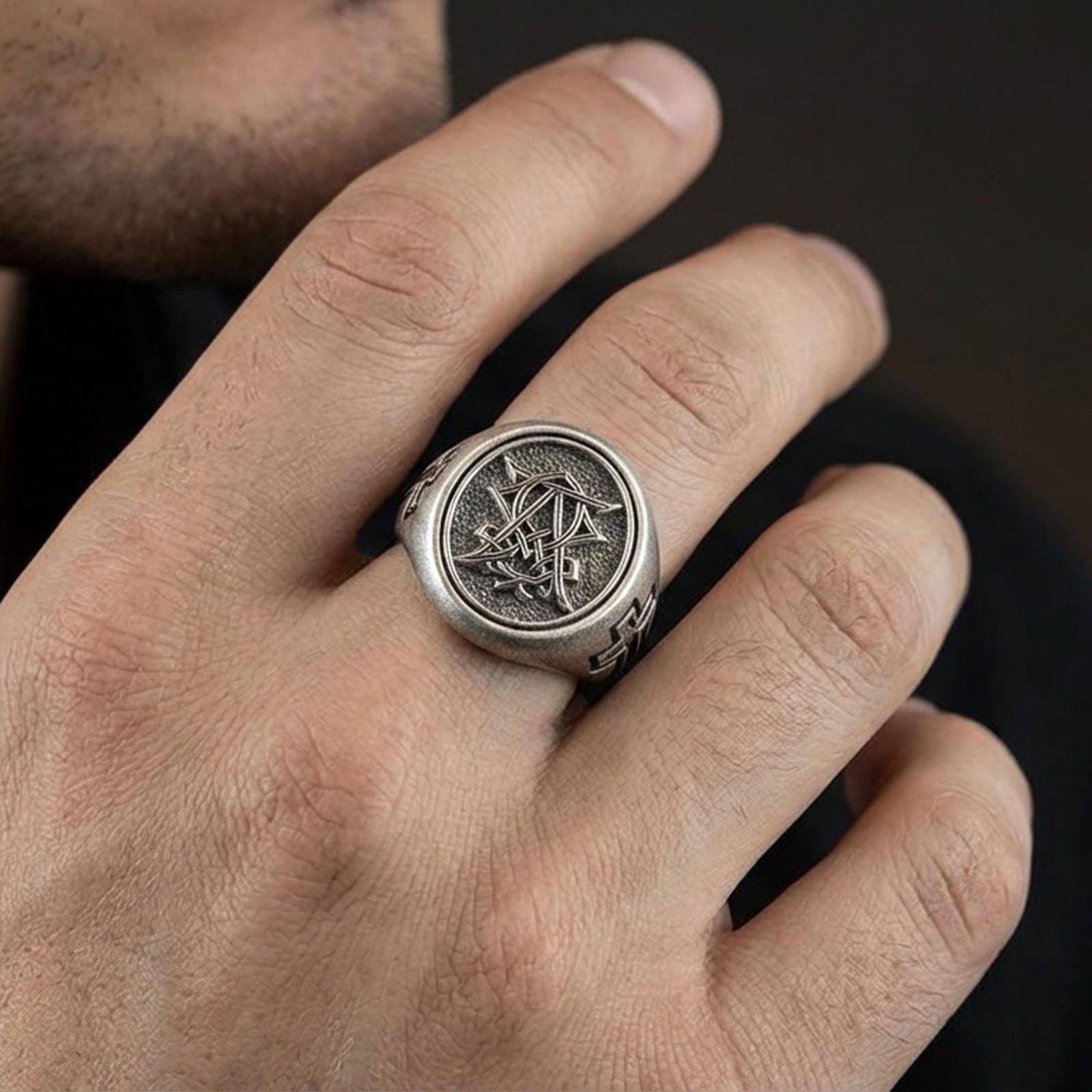 Oxidized 925 sterling silver Christian monogram signet ring worn on finger, cross-engraved band and detailed monogram seal