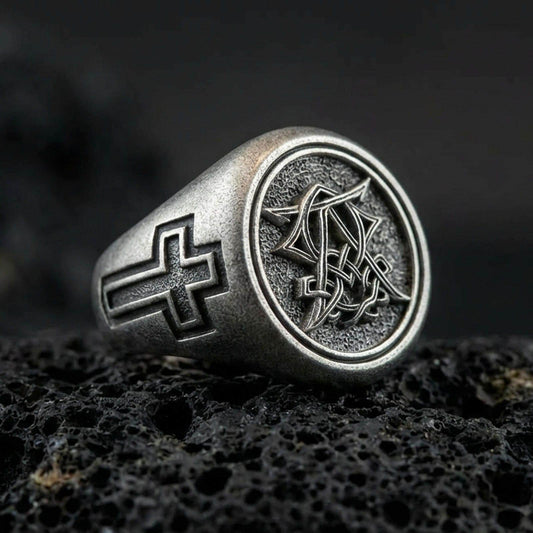 Oxidized 925 sterling silver Christian monogram signet ring on volcanic rock, cross-engraved band and intertwined letter emblem