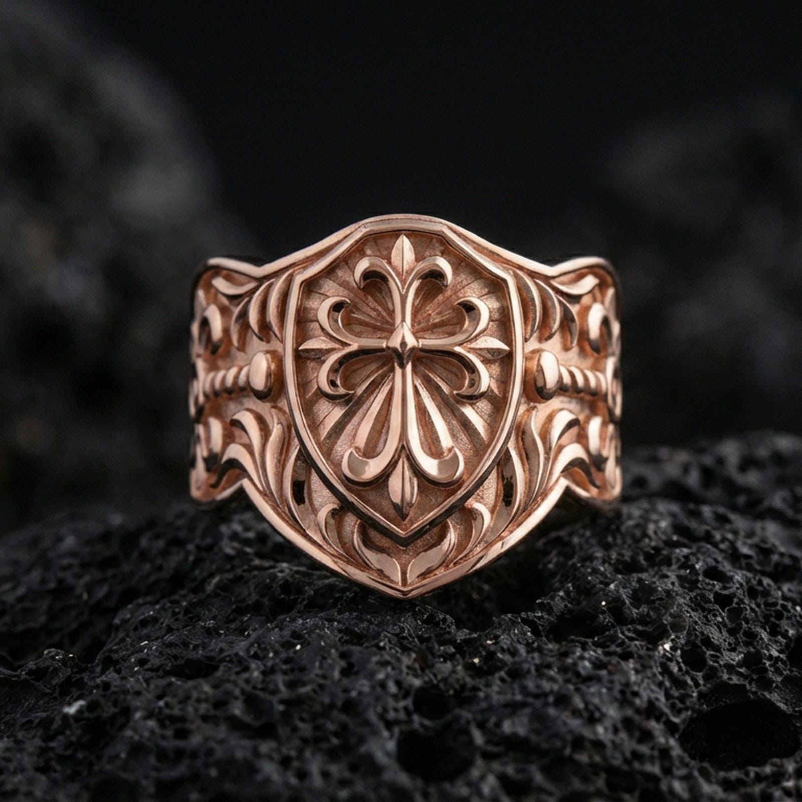Rose gold plated heraldic cross shield ring on volcanic stone, shield-shaped face with fleur-de-lis cross and vintage scroll details