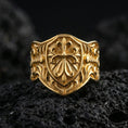 Load image into Gallery viewer, Gold plated heraldic cross shield ring on dark volcanic rock, medieval crest design with ornate cross and engraved band
