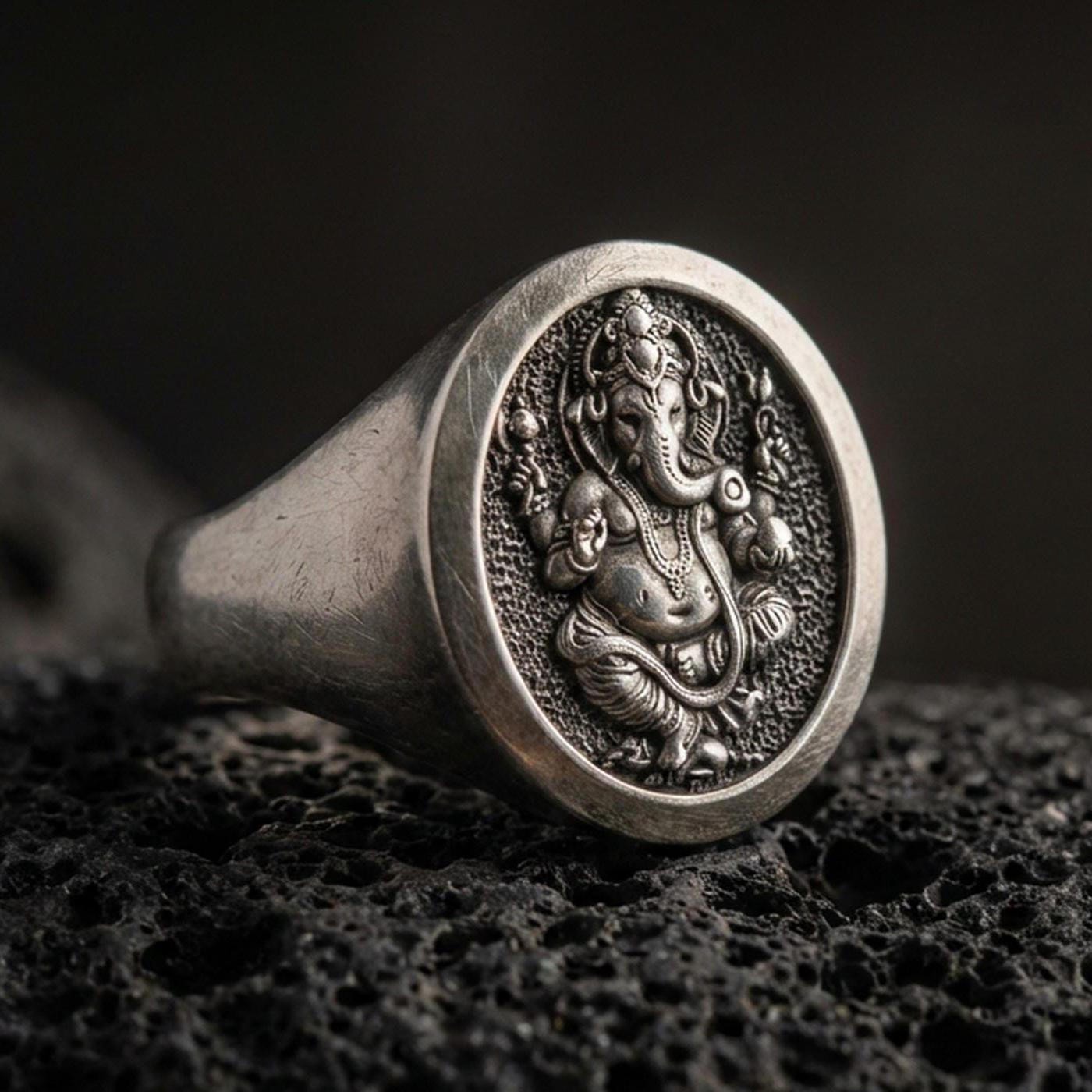 Oxidized 925 sterling silver Ganesha signet ring on volcanic rock, detailed elephant deity relief and textured background