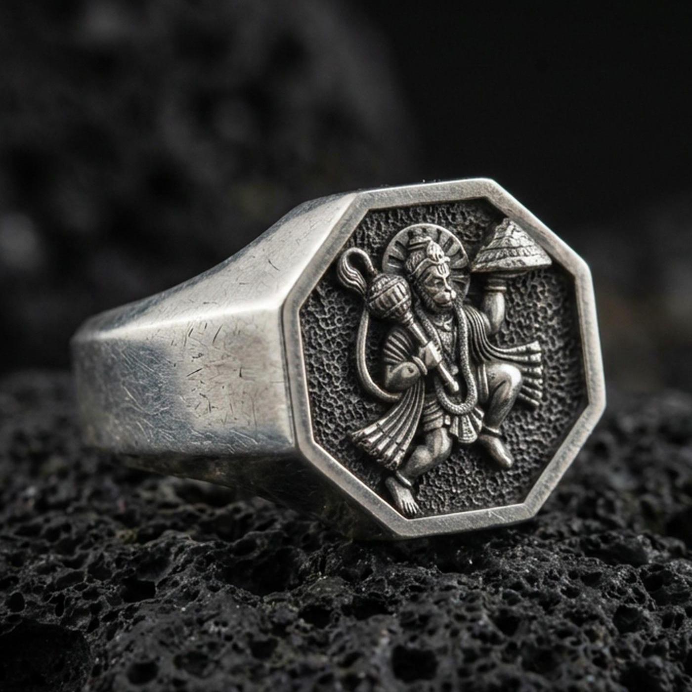 Oxidized 925 sterling silver Hanuman signet ring on volcanic rock, octagon face with detailed relief and textured background