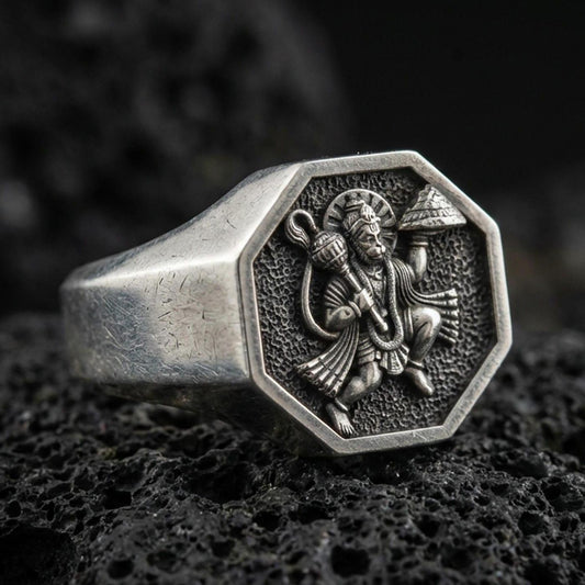 Oxidized 925 sterling silver Hanuman signet ring on volcanic rock, octagon face with detailed relief and textured background