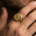 Load image into Gallery viewer, Gold plated multi-faced deity signet ring worn on finger, spiritual statement ring with raised relief carving and smooth band
