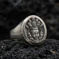 Load image into Gallery viewer, Oxidized 925 sterling silver multi-faced deity signet ring on volcanic rock, detailed Buddhist-inspired relief face engraving
