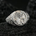 Load image into Gallery viewer, Polished silver Good Shepherd signet ring on porous volcanic stone, detailed Jesus and lamb engraving with smooth reflective frame
