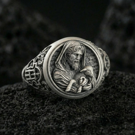 Oxidized 925 sterling silver Good Shepherd signet ring on volcanic rock, Jesus holding lamb relief with dark antiqued details