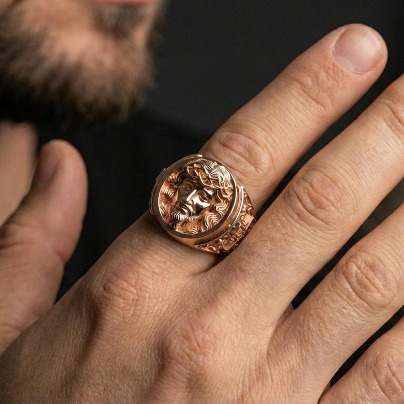 Rose gold plated Jesus Christ ring worn on finger, detailed portrait relief signet with warm luxury tone