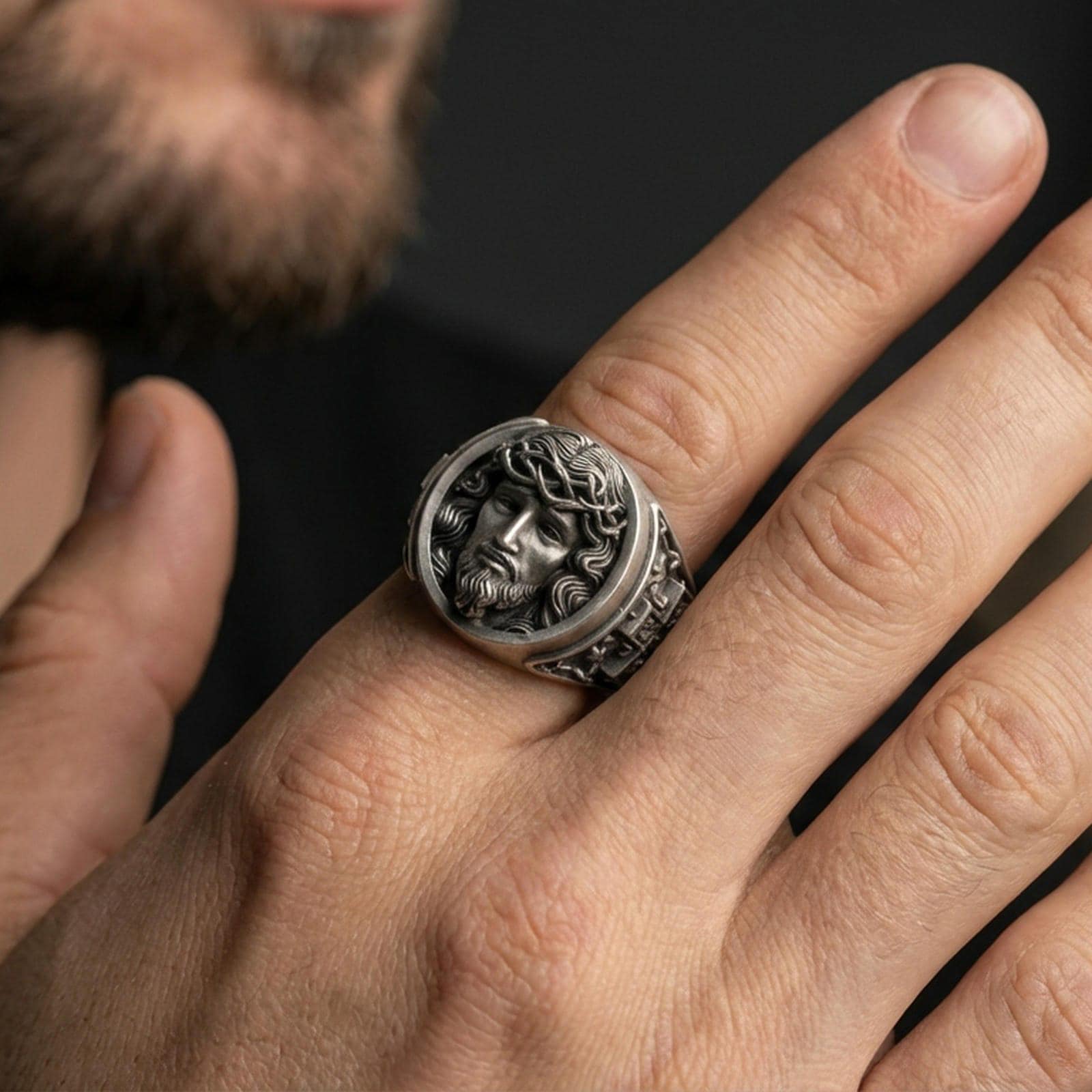 Oxidized 925 sterling silver Jesus ring worn on finger, crown of thorns portrait relief with dark antique finish