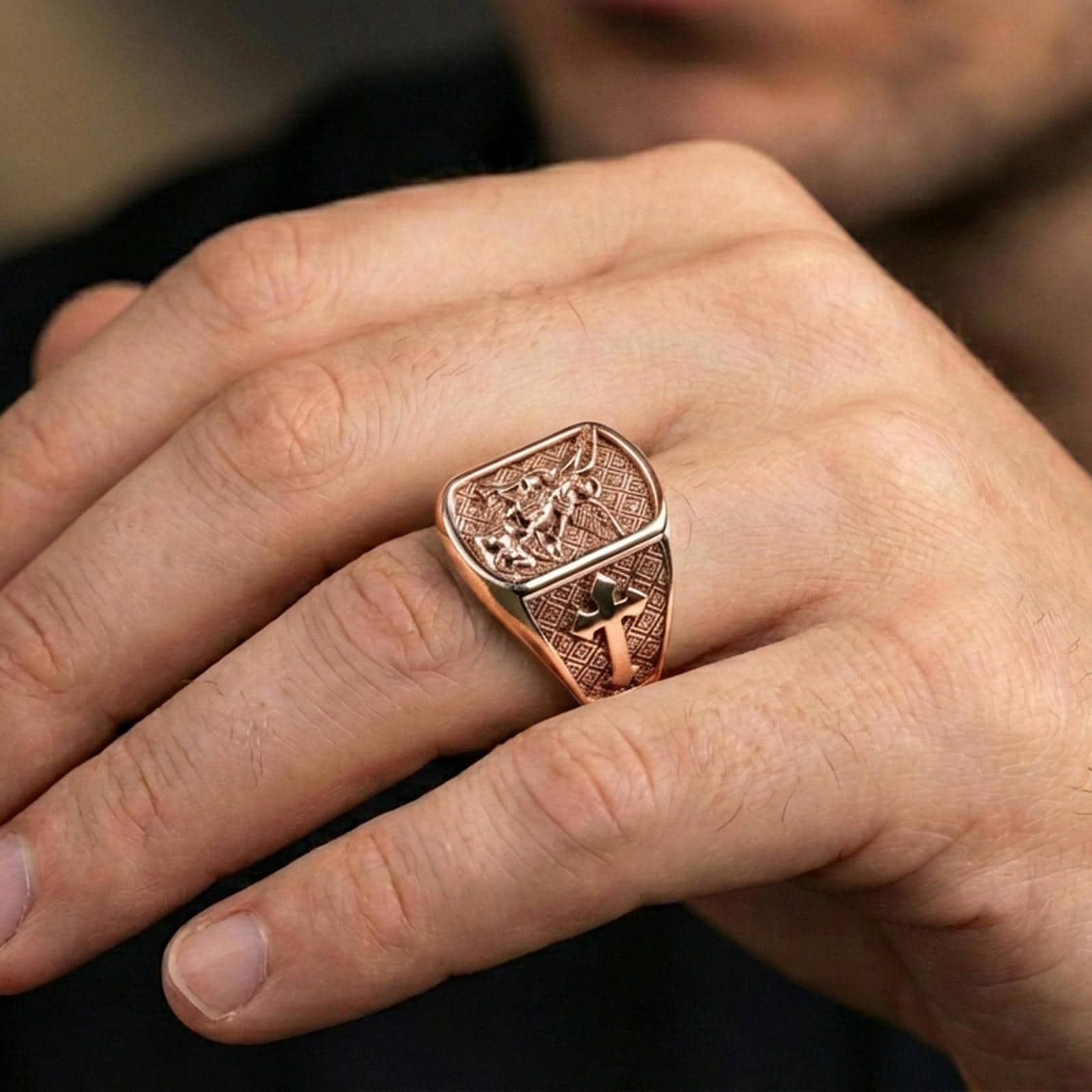 Rose gold plated Archangel Michael signet ring worn on finger, angel warrior relief with elegant warm luxury tone