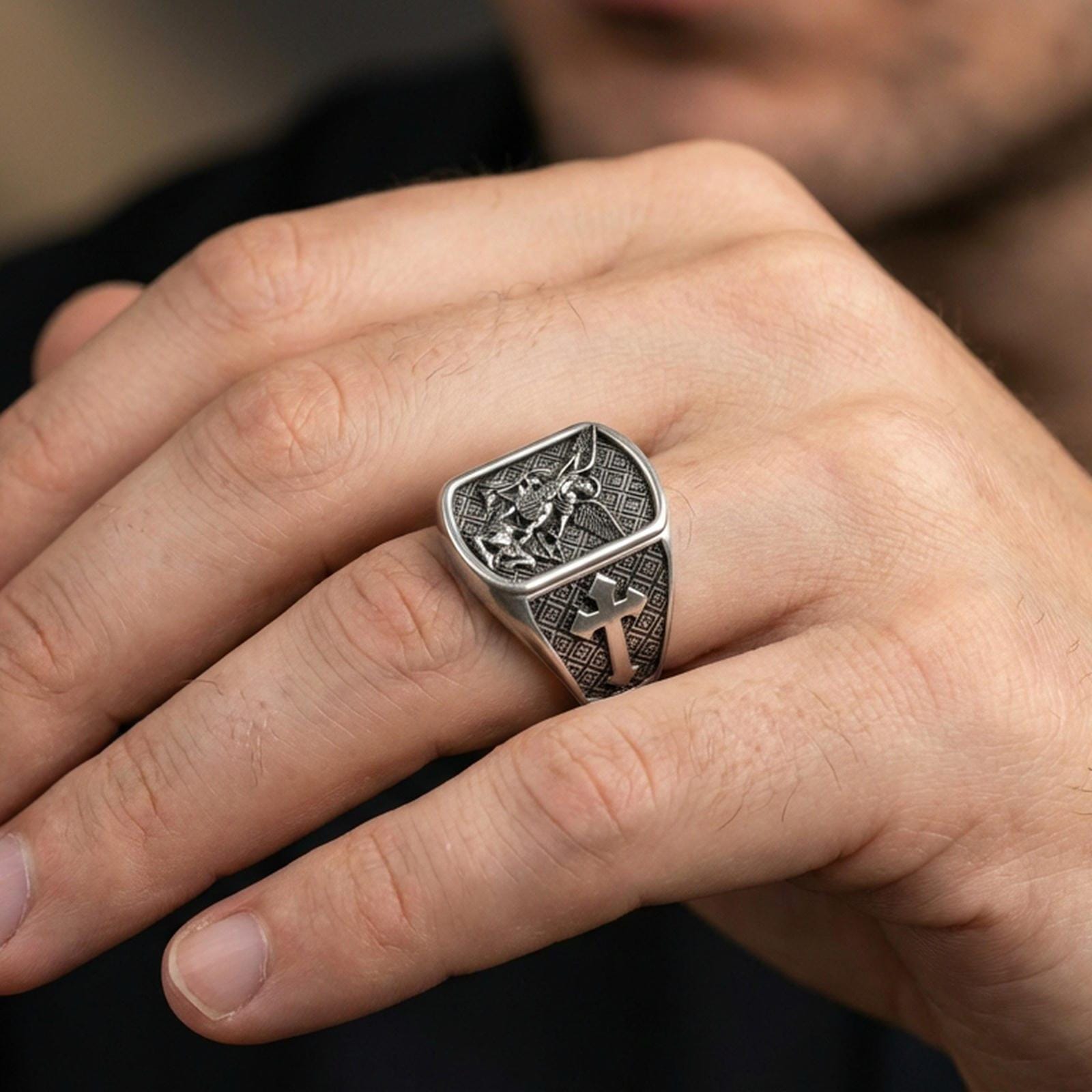 Oxidized 925 sterling silver Archangel Michael ring worn on finger, Michael conquers evil relief with cross side panel