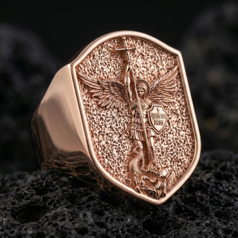 Rose gold plated Saint Michael signet ring on volcanic stone, shield-shaped face with angel battle scene and raised border