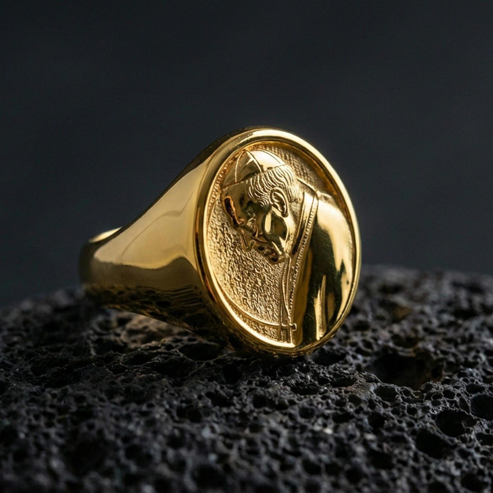 Gold plated Pope portrait signet ring on dark volcanic rock, Catholic religious medallion face with smooth bezel