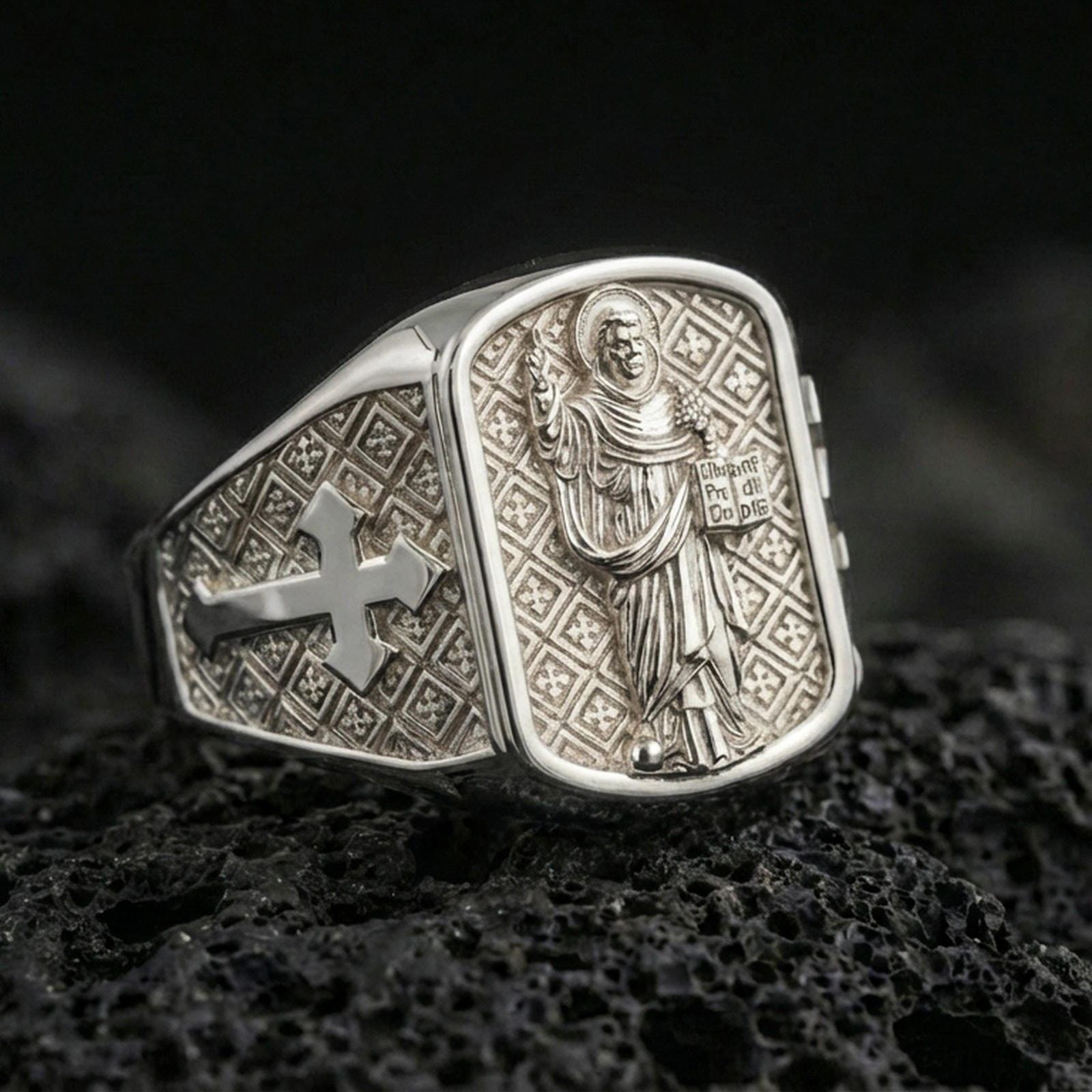 Polished silver Saint Dominic ring on porous volcanic stone, Dominican saint figure engraving and cross band