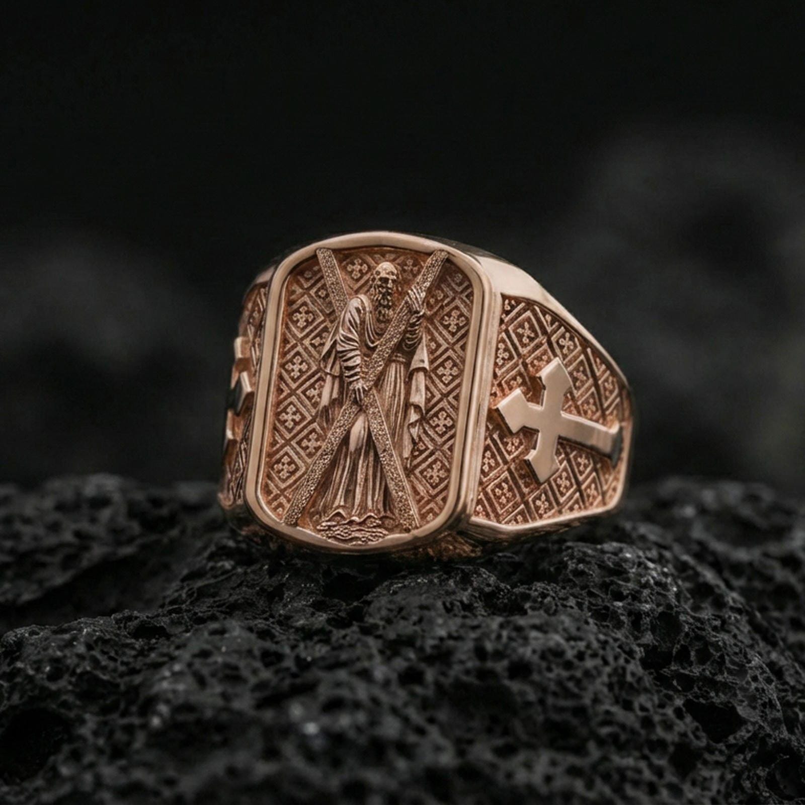 Rose gold plated Saint Andrew signet ring on dark volcanic stone, apostle relief with cross motif side detail
