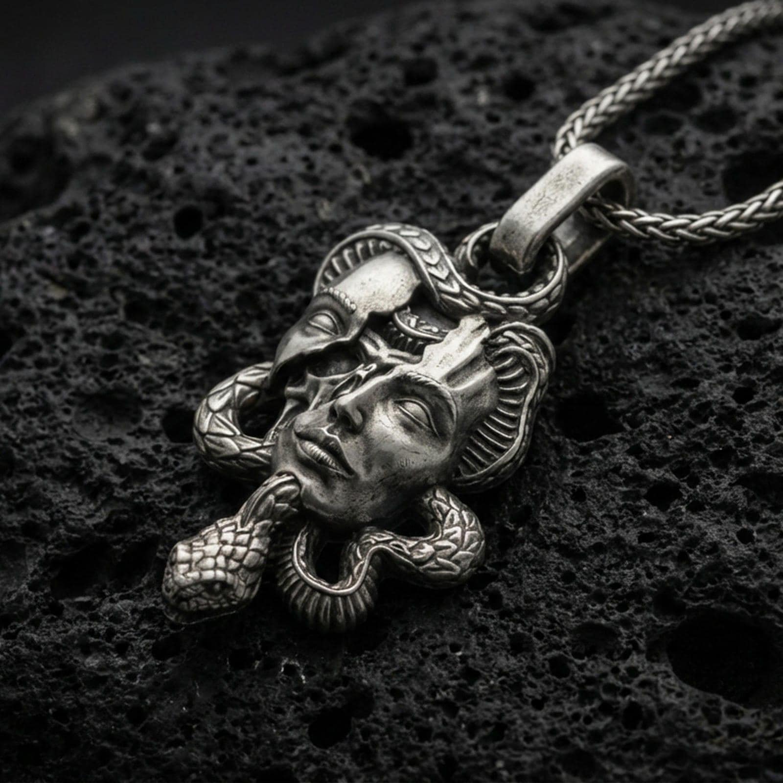 Oxidized 925 sterling silver Medusa skull pendant on volcanic rock, snake-wrapped memento mori necklace with detailed gothic face relief